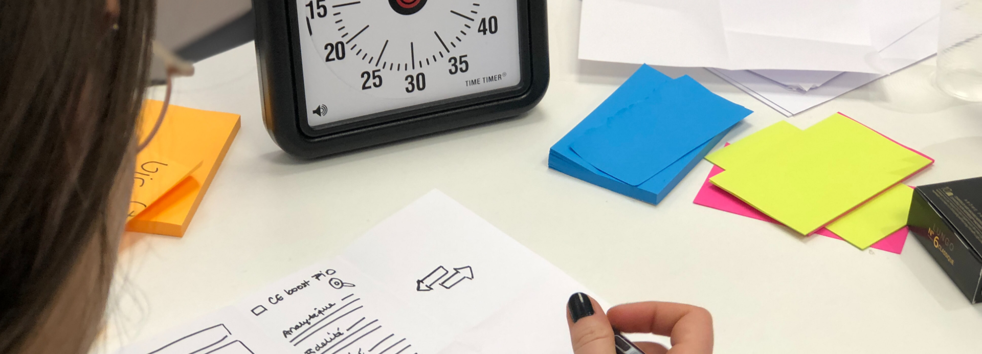 sketching eight ideas on paper with a timer counting down