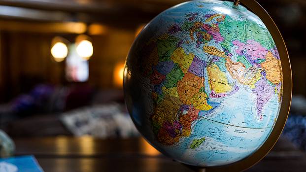 A globe of the Earth stands on a table at the front of a room.