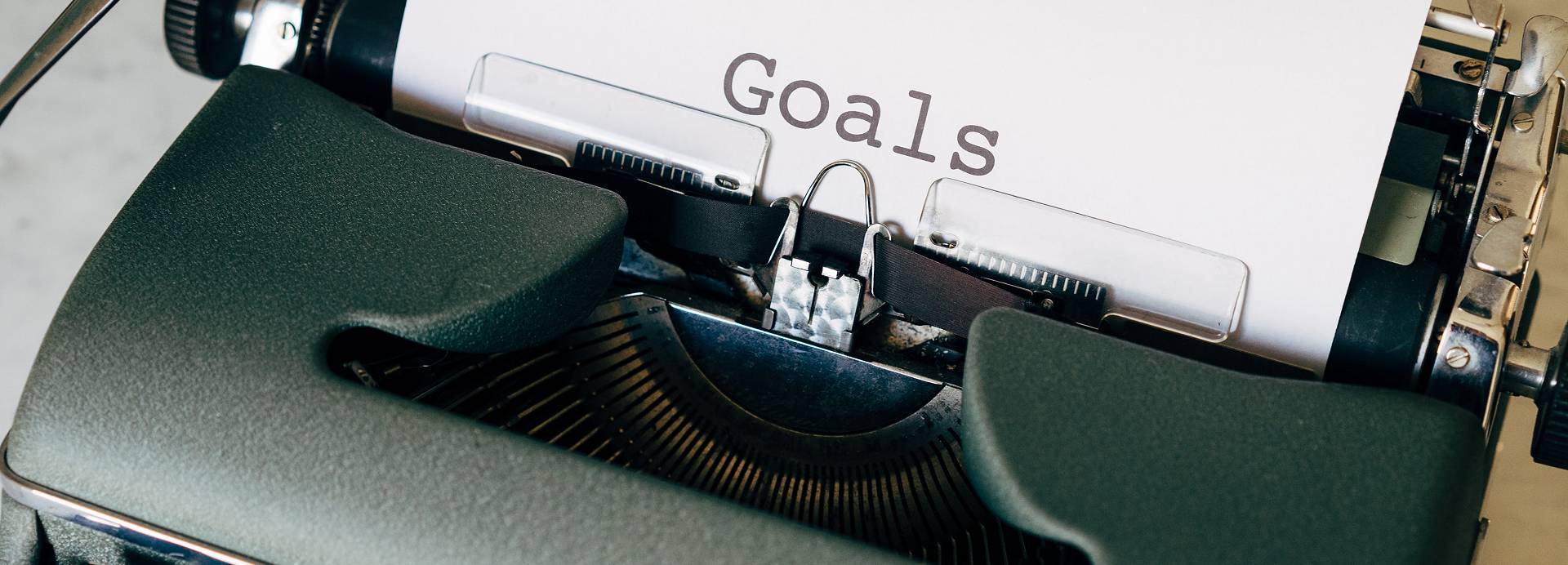 A black typewriter typing out the word 
